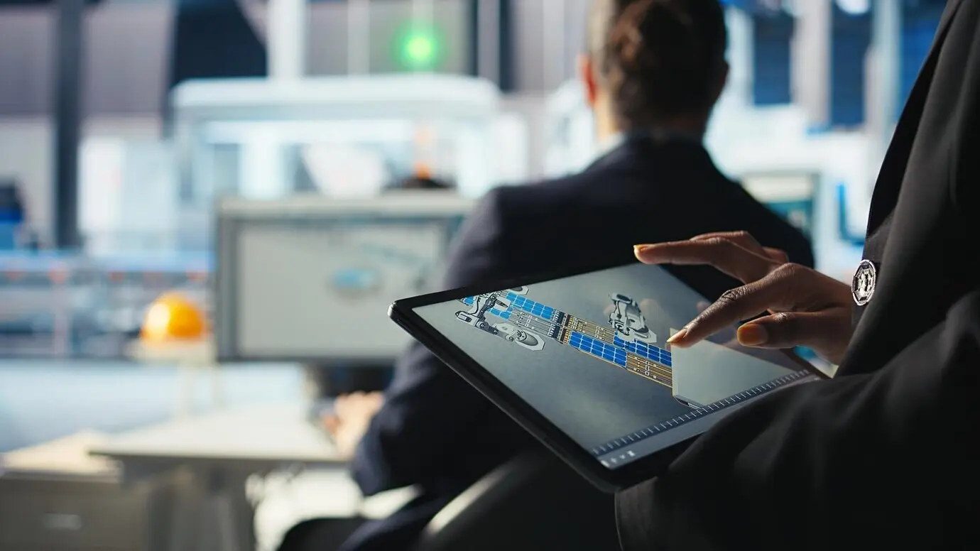 Experto de una fábrica dedicada a la fotovoltaica diseña líneas de producción en una aplicación CAD usando una tableta.